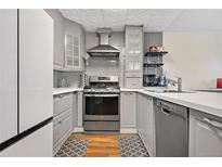 Modern kitchen featuring stainless steel appliances and gray cabinetry at 961 S Evanston Cir, Aurora, CO 80012