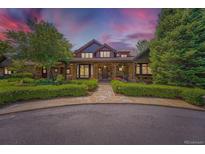 Stunning stone-clad home featuring a covered front porch and walkway lined by trimmed shrubs at 8576 Niwot Meadow Farm Rd, Niwot, CO 80503