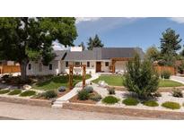 Well-maintained home featuring mature landscaping and solar panels at 14117 W 58Th Pl, Arvada, CO 80004