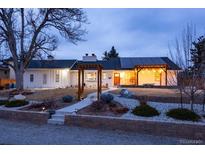 Ranch style home with a landscaped yard, pergola, and solar panels at 14117 W 58Th Pl, Arvada, CO 80004