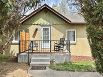 Charming home featuring a welcoming front porch with seating and a decorative sun accent at 2200 Teller St, Lakewood, CO 80214