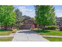 Charming two-story home with a well-manicured lawn, mature trees, and a spacious driveway leading to an attached two-car garage at 25402 E Glasgow Pl, Aurora, CO 80016