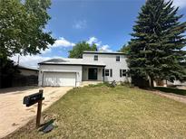 Charming two-story home featuring a well-maintained lawn, attached garage, and classic curb appeal at 7431 Webster St, Arvada, CO 80003