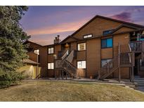 Charming condo exterior with wood siding, dual staircase entries, and well-maintained landscaping at 9077 W 88Th Cir, Denver, CO 80021