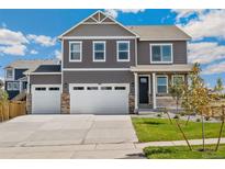 Inviting two-story home boasts a three-car garage, charming front porch, and well-manicured lawn at 14249 Beebalm Ave, Parker, CO 80134