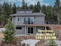 Charming gray two-story home with a spacious deck and beautiful forest surroundings at 31932 Steven Way, Conifer, CO 80433