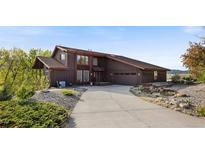 Inviting exterior showcasing an oversized driveway, landscaping, and a well-maintained brown home at 3900 Bogey Ct, Longmont, CO 80503