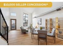 Bright living room featuring hardwood floors, high ceilings, and modern furnishings at 3195 Blake St # 201, Denver, CO 80205