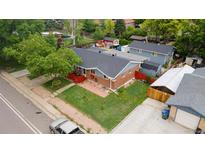 Charming brick home with a spacious yard and mature trees, featuring a red porch and an inviting exterior at 1263 W 103Rd Pl, Northglenn, CO 80260
