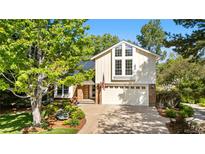 Inviting two-story home with manicured landscaping, a brick facade, and an attached two-car garage at 8535 E Otero Cir, Centennial, CO 80112