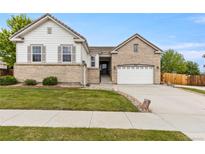 Charming two-story home with a well-manicured lawn, two-car garage, and inviting curb appeal at 4545 Oxbow Dr, Brighton, CO 80601