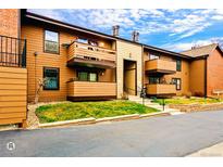Exterior shot of townhome featuring balconies and front lawn at 7080 W 20Th Ave # 202, Lakewood, CO 80214