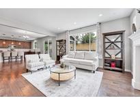 Bright living room with large windows, hardwood floors, and contemporary furnishings at 10887 Endeavor Dr, Parker, CO 80134