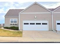 Tan two-car garage townhome with landscaping at 15555 E 40Th Ave # 118, Denver, CO 80239