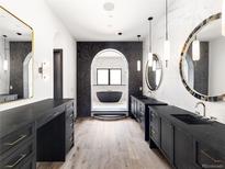 Luxurious primary bathroom featuring dual vanities, archways, and freestanding tub at 5392 Lions Paw St, Castle Rock, CO 80104