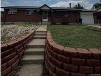 Charming red brick ranch-style home with a well-maintained lawn and inviting front entrance at 8278 Cherokee St, Denver, CO 80221