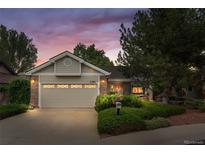 Charming single-story home with a well-maintained lawn, mature trees and two-car garage, bathed in the warm light of dusk at 1181 E 130Th Pl, Thornton, CO 80241