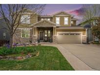 Beautiful two-story home with stone accents, a landscaped yard, and a charming front porch at 2349 Hickory Pl, Erie, CO 80516