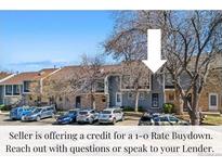 Exterior view of the home showcasing the well-kept property with a parking area and blue skies at 8773 W Cornell Ave # 10, Lakewood, CO 80227