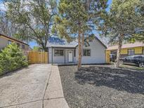 Charming single-story home with a well-maintained yard, inviting entrance, and mature trees at 655 S Osceola St, Denver, CO 80219