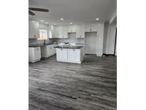 Bright kitchen features modern white cabinets, gray subway tile backsplash, and a spacious center island at 655 S Osceola St, Denver, CO 80219
