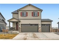 Charming two-story home featuring a three-car garage, covered porch, and tasteful red shutter accents at 140 Racer St, Bennett, CO 80102
