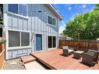 Inviting backyard with a wooden deck, outdoor seating, string lights, and a well-maintained fence at 2854 N Lowell Blvd, Denver, CO 80211