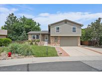 Charming two-story home featuring a manicured lawn and a brick-accented facade at 10961 Gray Cir, Westminster, CO 80020