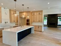 Bright, open kitchen with a waterfall island, custom cabinets, and stylish pendant lighting at 2442 S Saint Paul St, Denver, CO 80210