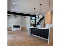 Open living room with hardwood floors, modern lighting, and staircase at 2442 S Saint Paul St, Denver, CO 80210