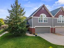 Charming townhome with well-manicured lawn, attached garage, and inviting curb appeal at 3212 Pierce St, Wheat Ridge, CO 80033