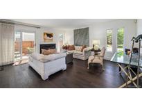 Bright living room featuring hardwood floors, a fireplace, and access to a private patio at 1050 S Monaco Pkwy # 35, Denver, CO 80224