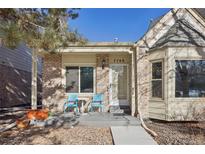 Inviting exterior of a charming brick home with a covered porch and well-manicured landscaping at 7708 S Cove Cir, Centennial, CO 80122