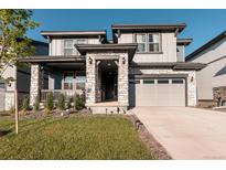 Charming two-story home with stone accents, covered porch, and well-manicured lawn at 2967 S Quaker St, Morrison, CO 80465