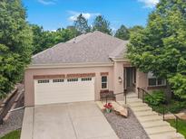 Charming home featuring a two-car garage, concrete steps, and a cozy front bench with mature landscaping at 6700 W Dorado Dr # 47, Littleton, CO 80123