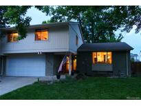 Two story home with attached garage, brick and siding, and an American flag in the front yard at 1936 S Poplar St, Denver, CO 80224
