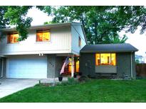 Charming two-story home with well-manicured lawn, brick accents, and attached garage at 1936 S Poplar St, Denver, CO 80224