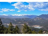 Expansive mountain view featuring snow-capped peaks, rolling hills, and a vibrant blue sky with scattered clouds at 25952 Fern Gulch Rd, Evergreen, CO 80439