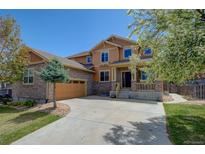Inviting two-story home showcasing stone accents, manicured lawn, and a charming covered front porch at 25994 E Peakview Pl, Aurora, CO 80016