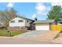 Charming two-story home with brick accents, green trim, and a spacious driveway leading to a two-car garage at 7158 W Roxbury Ave, Littleton, CO 80128