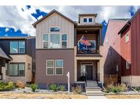 Charming two-story home featuring a covered balcony with an American flag and manicured front yard at 16762 Tejon Ln, Broomfield, CO 80023