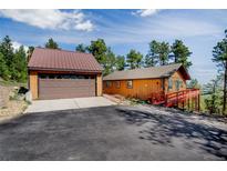 Cozy cabin home with a detached garage and beautiful mountain views from the elevated deck at 8624 S Doubleheader Ranch Rd, Morrison, CO 80465
