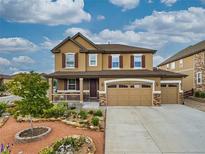 Stunning two-story home showcasing a charming facade, three-car garage, and beautifully landscaped front yard at 784 Sweet Pine Ct, Monument, CO 80132
