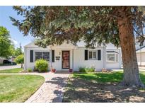 Charming single-story home with a brick walkway, green lawn, and mature landscaping at 4197 S Grant St, Englewood, CO 80113