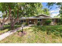 Charming single-story home with a well-maintained lawn, mature trees, and a welcoming walkway at 2934 S Columbine St, Denver, CO 80210