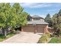Inviting two-story home with mature trees, a two-car garage, and a basketball hoop at 2043 Fendlebrush St, Highlands Ranch, CO 80129