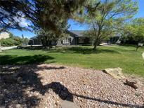 Charming single story home with a well-manicured lawn and mature trees at 8659 E Kenyon Ave, Denver, CO 80237