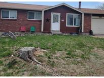Charming brick home featuring a well-manicured lawn and inviting front entrance at 9008 Dover St, Broomfield, CO 80021