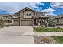Charming two-story home with a stone and siding exterior, well-manicured lawn, and a three car garage at 8133 Arapahoe Peak St, Littleton, CO 80125