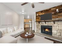 Inviting living room featuring a stone fireplace, sofa, and wood floors at 185 S Sable Blvd # T18, Aurora, CO 80012